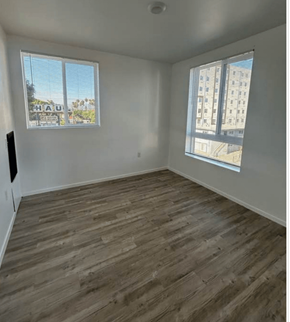 Los Angeles apartment for rent - A room with wooden flooring and two windows.