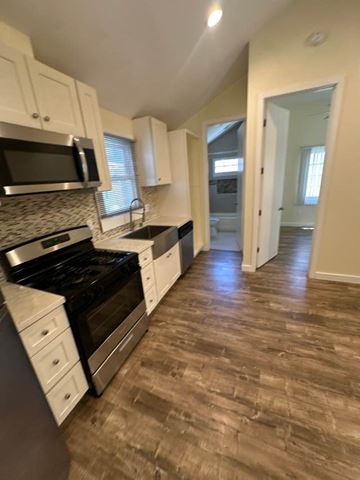 Los Angeles apartment for rent - A kitchen with a black stove top oven and white cabinets.