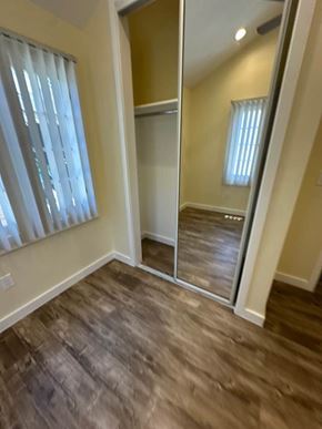 Los Angeles apartment for rent - A room with a wooden floor and a large mirror.