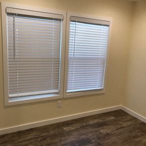 Los Angeles apartment for rent - Two windows with white blinds in a room with wooden flooring.