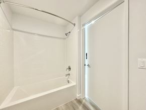 Los Angeles apartment for rent - A white bathroom with a tub and a door.