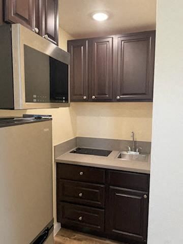 Los Angeles apartment for rent - A kitchen with brown cabinets and a white refrigerator.