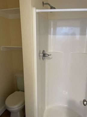 Los Angeles apartment for rent - A white toilet sits next to a white shower door.