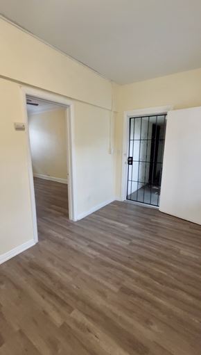 Los Angeles apartment for rent - A room with wooden flooring and two doors, one of which is open.