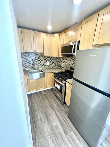 Los Angeles apartment for rent - A kitchen with a stainless steel refrigerator and wooden cabinets.