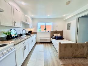 San Pedro apartment for rent - A kitchen with white cabinets and a stove top oven.