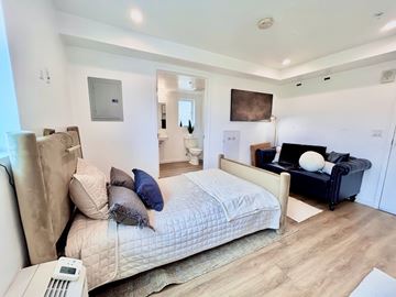 San Pedro apartment for rent - A bedroom with a large bed and a couch.