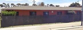 Los Angeles apartment for rent - A red building with a black fence in front.
