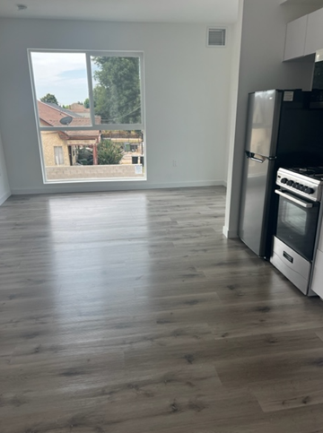 Los Angeles apartment for rent - A kitchen with a black fridge and stove next to a window.