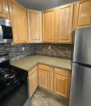 Los Angeles apartment for rent - A kitchen with wooden cabinets and a black stove top.