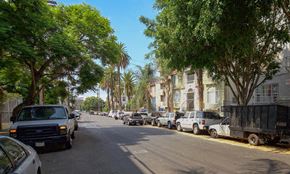 Los Angeles apartment for rent - A street lined with parked cars and trees.