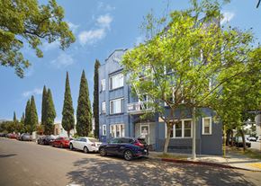 Los Angeles apartment for rent - Cars parked on a street in front of a blue building.
