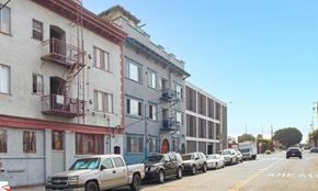 Los Angeles apartment for rent - A row of parked cars on a street with buildings on either side.