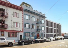 Los Angeles apartment for rent - A row of three-story buildings with cars parked in front.