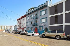 Los Angeles apartment for rent - A row of cars parked on a street in front of a building.
