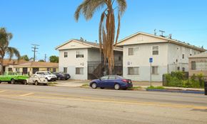 Los Angeles apartment for rent - A blue car is parked in front of a white house.