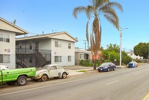 Los Angeles apartment for rent - A street with a green truck and a white car with orange rims.