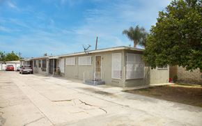 Compton apartment for rent - A row of houses with a car parked in front of the first house.