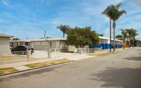 Compton apartment for rent - A street view of a residential area with houses and trees.