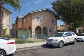 Long Beach apartment for rent - A white car is parked in front of a brown building.