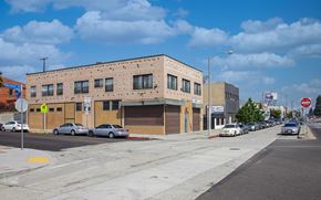 Los Angeles apartment for rent - A street view of a building with cars parked in front.