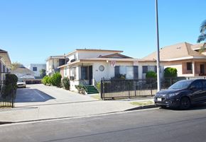 Los Angeles apartment for rent - A black car is parked on the right side of a street.