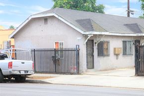 Los Angeles apartment for rent - A white truck is parked in front of a house with a black fence.