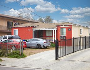 Los Angeles apartment for rent - a house with a fence and cars parked in front of it