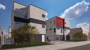 Los Angeles apartment for rent - A modern building with a red and grey facade stands under a blue sky.