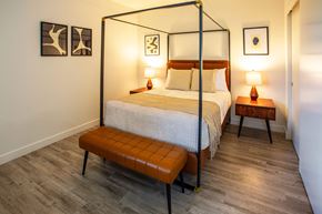 Los Angeles apartment for rent - A bedroom with a four poster bed and a bench in front of it.