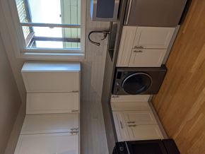 Oakland apartment for rent - a small laundry room with white cabinets and a washing machine