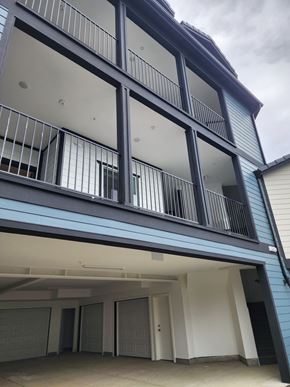 Fontana townhouse for rent - A modern building with a balcony and garage doors.