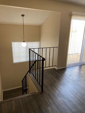 Ontario townhouse for rent - A staircase with a black railing and a light hanging from the ceiling.