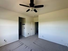 Oceanside townhouse for rent - A room with a ceiling fan and carpeted floor.