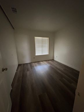 Upland house for rent - A room with wooden floors and a window with blinds.
