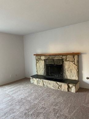 Alta Loma house for rent - an empty living room with a stone fireplace