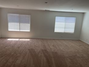 Fontana house for rent - an empty living room with wood floors and two windows