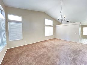 Hesperia house for rent - A room with a carpeted floor and a chandelier hanging from the ceiling.