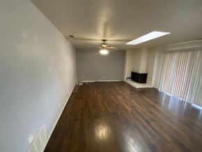 Victorville apartment for rent - an empty living room with wood flooring and a large window