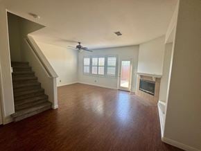 Oceanside townhouse for rent - A living room with a staircase and a fireplace.