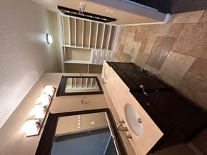 Corona house for rent - A bathroom with a sink, mirror, and lighting fixtures.