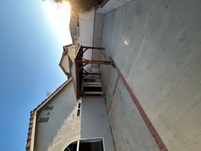 Corona house for rent - A building with a staircase attached to its side.
