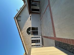 Corona house for rent - A building with a round window and a white door.
