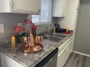 West Covina apartment for rent - A kitchen counter with a tray of wine glasses and a vase of flowers.