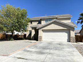 Victorville house for rent - A house with a garage door and a driveway.