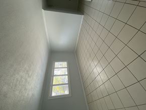 Ontario triplex for rent - A small window with a grid pattern on the wall.