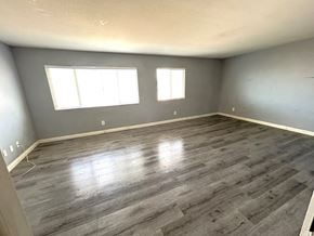 Victorville house for rent - A room with grey flooring and two windows.