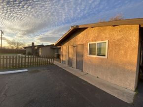 Apple Valley triplex for rent - A house with a brown stucco exterior and a wooden fence.