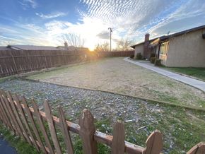 Apple Valley triplex for rent - A backyard with a wooden fence and a house in the background.
