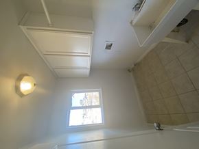 Hesperia house for rent - A bathroom with a window and a tiled shower.